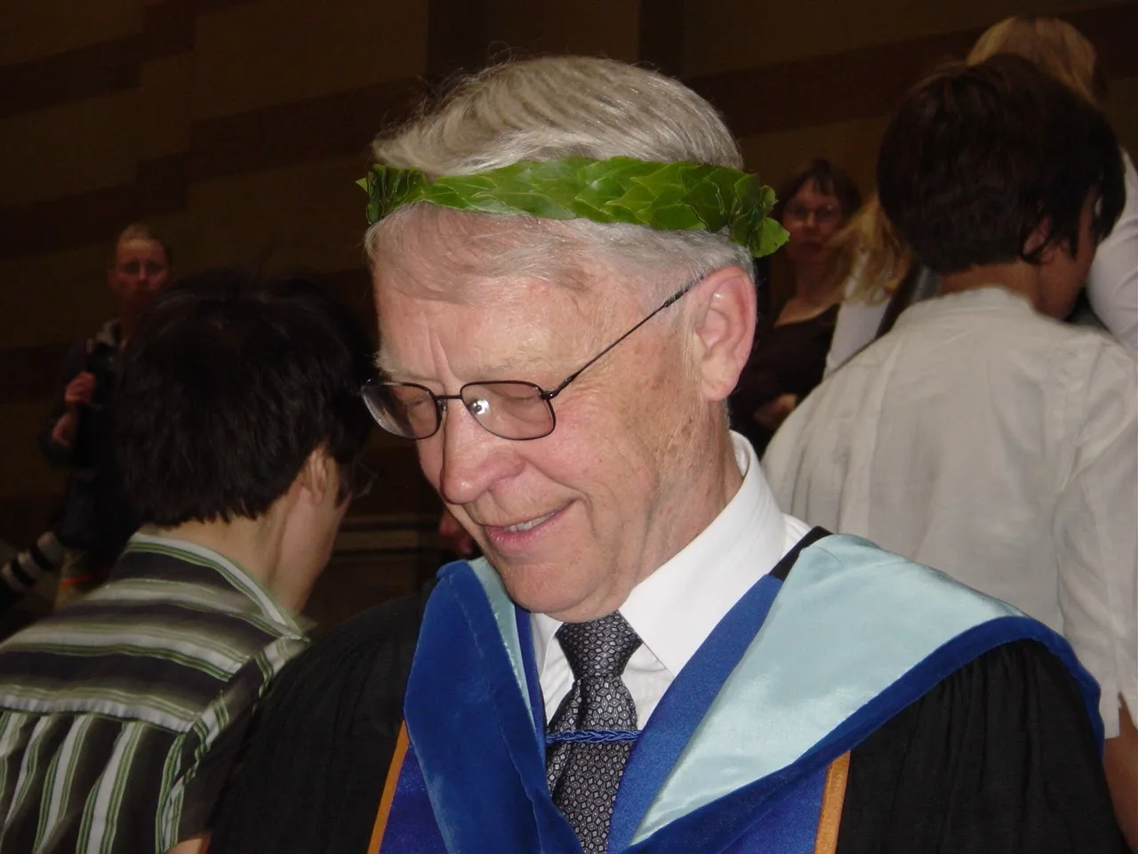 Gaalen in academic robes, smiling with a guest